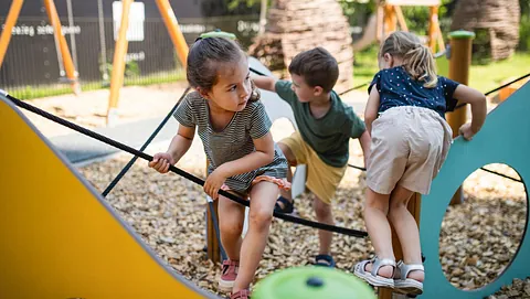 Tre barn som leker ute